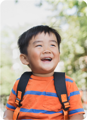 Toddler smiles and looks into the sun