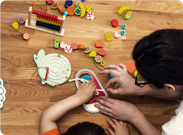 small-early-childhood-educator-with-toys-and-child A practitioner works with a child on skills development