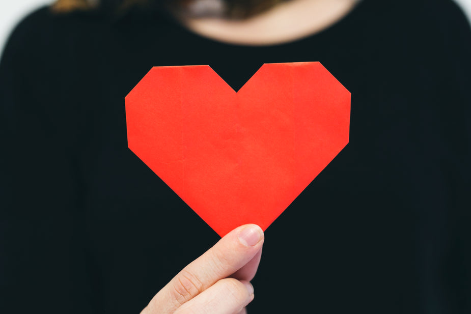 Hand holding a red paper heart