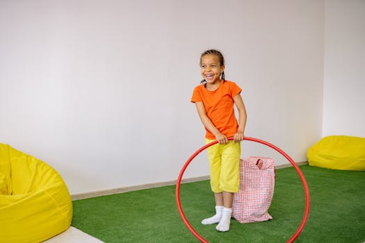 pexels-photo-8613144-8613144 A smiling girl enjoys playing with a hula hoop indoors, surrounded by bean bags.