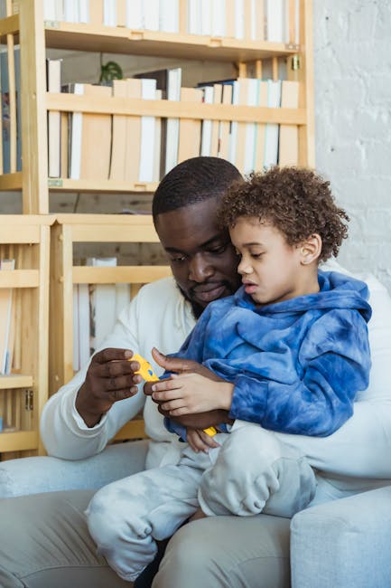 A father and son enjoying quality time together while playing with a toy indoors.
